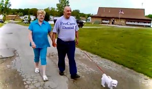 An older couple talking about geriatric dentistry from ProCare Family Dental while walking their little white Bichon Frisé...