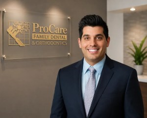 Dr. Antonio Ganios, Partner Dentist at ProCare Family Dental, standing in front of the ProCare Family Dental office sign in Morton Grove, Illinois.