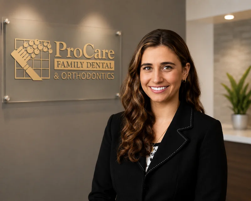 Dr. Penelope Danos, Partner Dentist at ProCare Family Dental, standing in front of the ProCare Family Dental office sign in Morton Grove, Illinois.